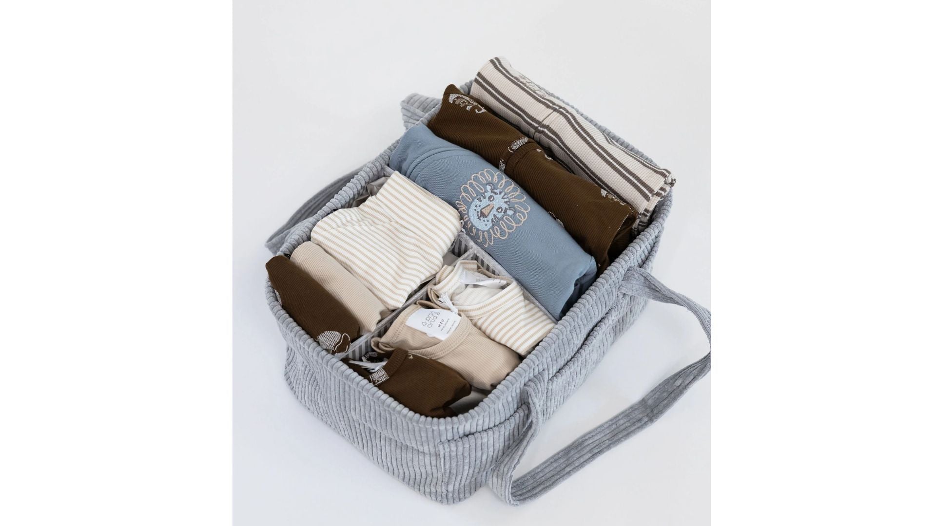 מארז ליולדת מבית בינה ובינו – בגדי תינוק רכים ומקופלים בגוונים טבעיים בתוך סל אחסון בד מעוצב