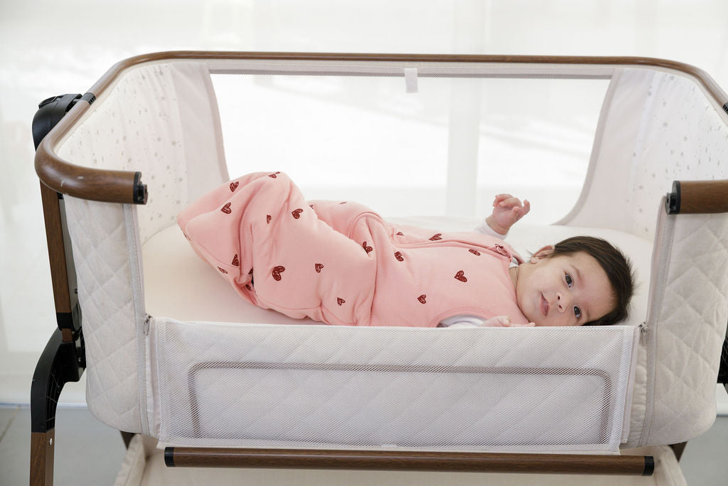 תינוקת בעריסה עם שק שינה ורוד עם לבבות אדומים - בינה ובינו